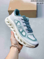 Side view of a white On Cloudtilt Remix sneaker with teal accents and a sculpted sole.