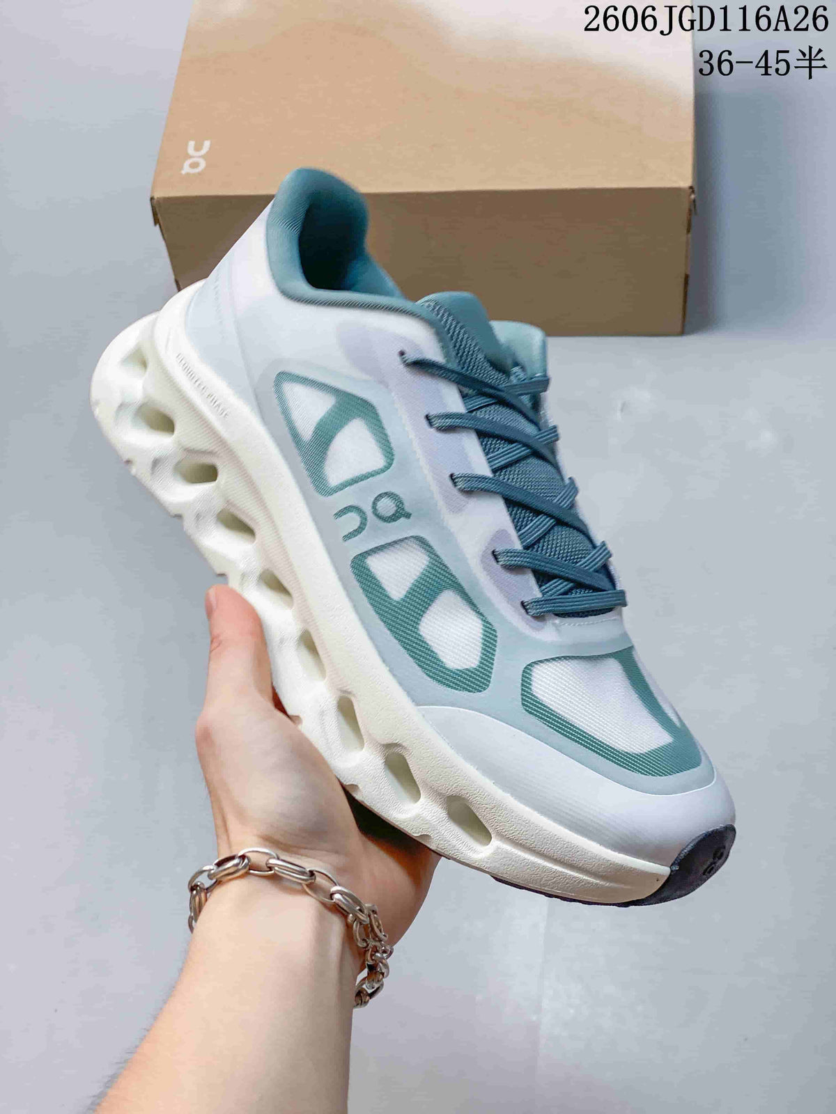 Side view of a white On Cloudtilt Remix sneaker with teal accents and a sculpted sole.