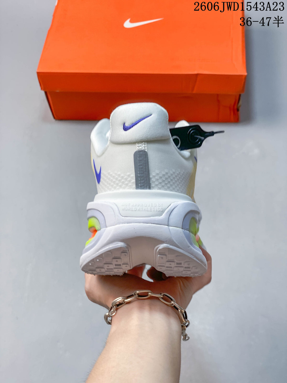 Rear view of the white running shoe with purple accents and sculpted heel details.