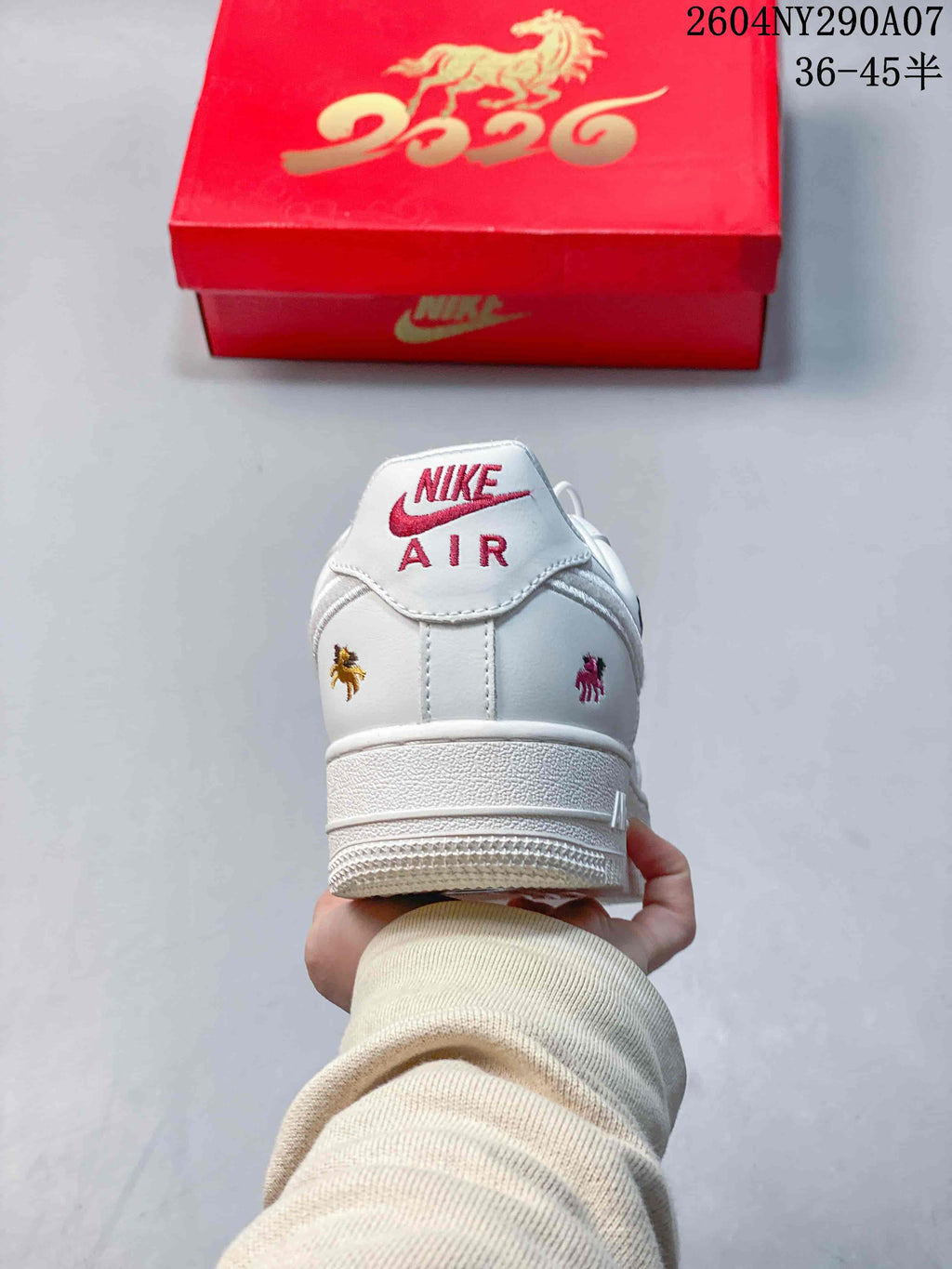 Rear view of a white sneaker with visible Nike Air branding and colorful embroidered horse-themed details.