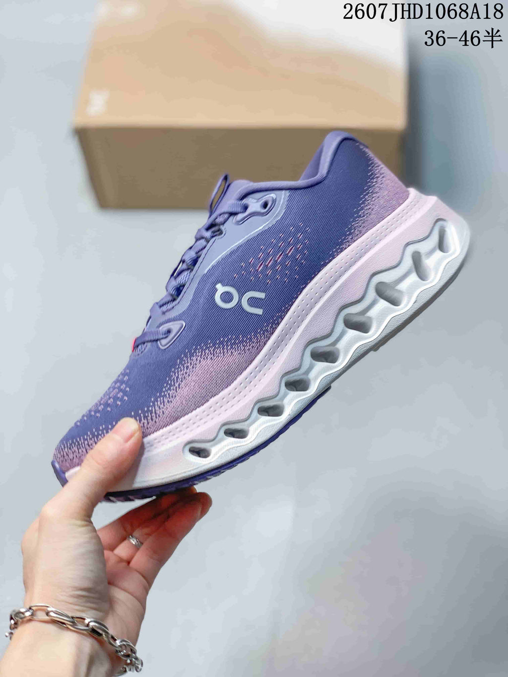 Side profile showing the purple patterned upper, side branding, white midsole, and segmented outsole openings.