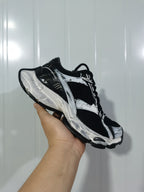 Black-and-white sneaker shown from the opposite side, highlighting the mesh panels and sculpted sole.