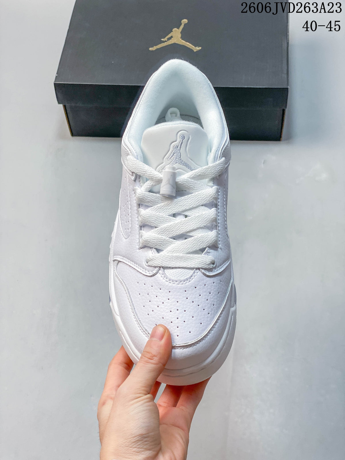 Top view of a white Jordan low-top sneaker with perforated toe and lace-up closure