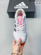 Top view showing the white mesh toe box, laces, pink tongue and adidas branding.