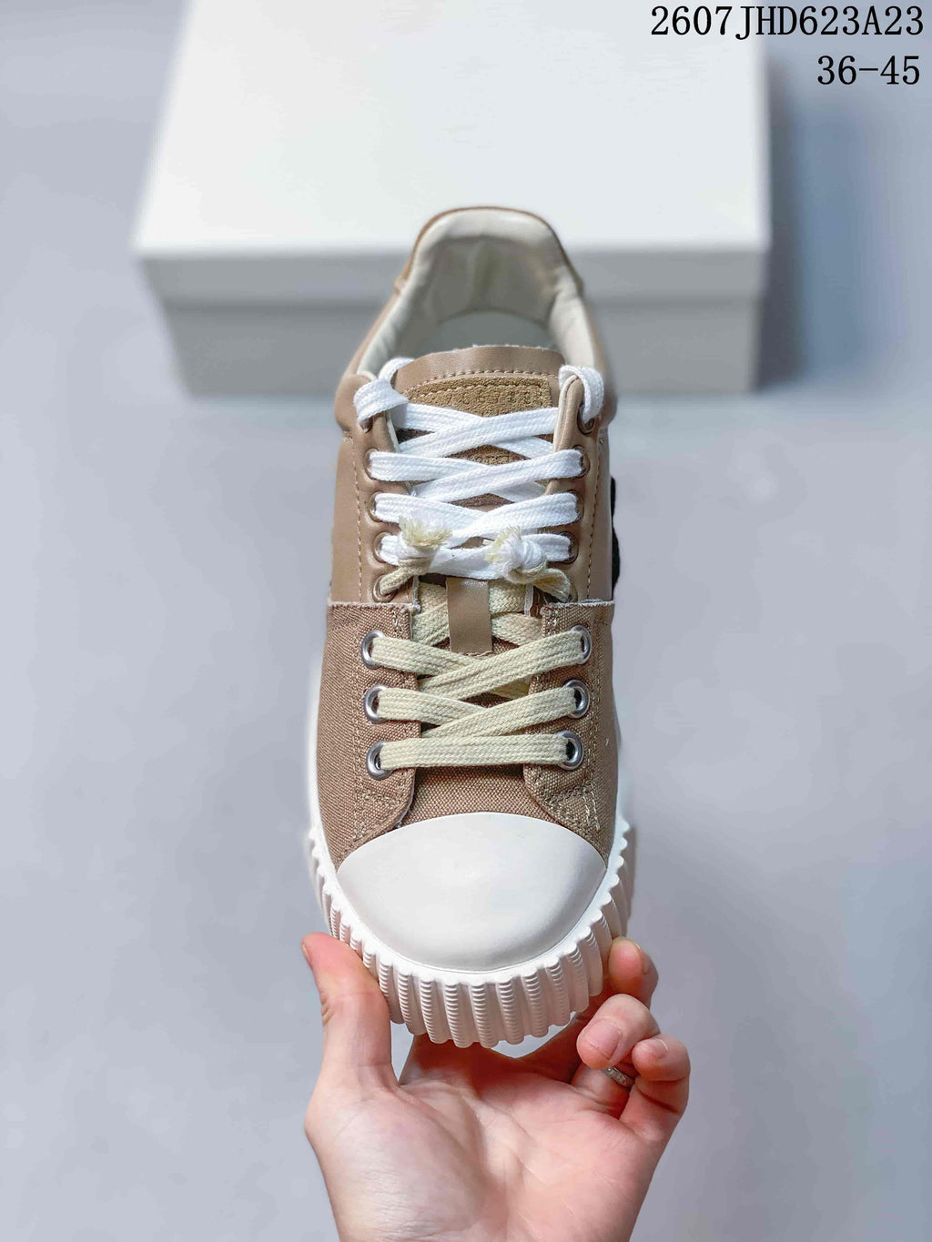 Front view showing the white toe cap, layered laces, metal eyelets, and textured sole edge.