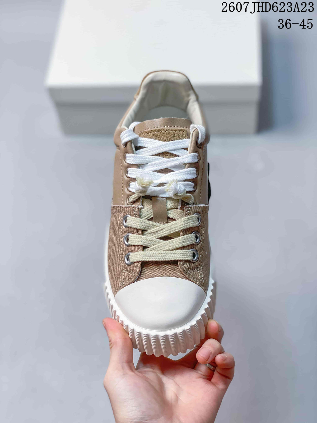 Front view showing the white toe cap, layered laces, metal eyelets, and textured sole edge.