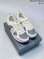 Pair of off-white Emporio Armani EA7 low-top sneakers with gray mesh panels, green accents, and orange-toned outsoles on a branded shoe box.