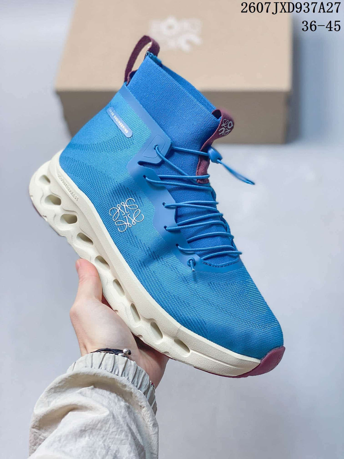 Angled side view showing the blue upper, decorative branding, pull tab and sculpted white sole.