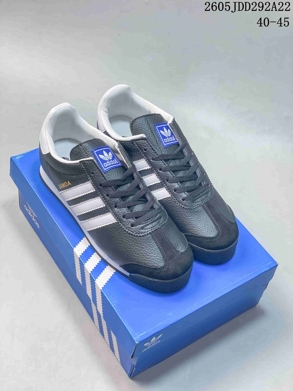 Pair of dark gray and white adidas Samoa sneakers displayed on a blue shoebox; the image shows the size range 40–45.