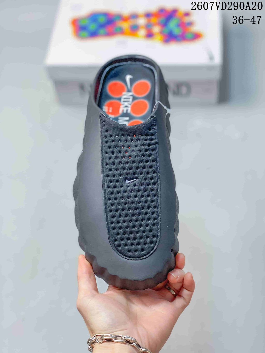 Top view of a black and gray slip-on slide with a perforated upper and Nike branding.