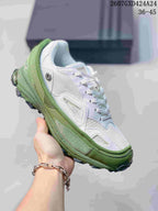 Close-up of a white and light green OZWEEGO sneaker with contrasting green overlays and outsole details.