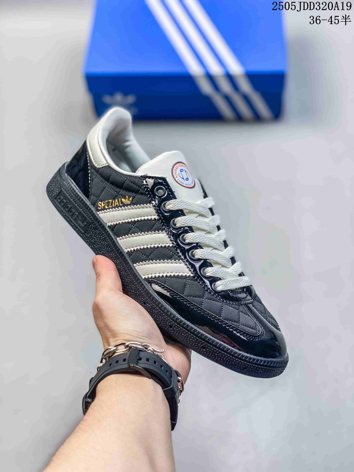 Angled side view of a black and white sneaker with white stripes, gold Spezial branding and a textured black sole.