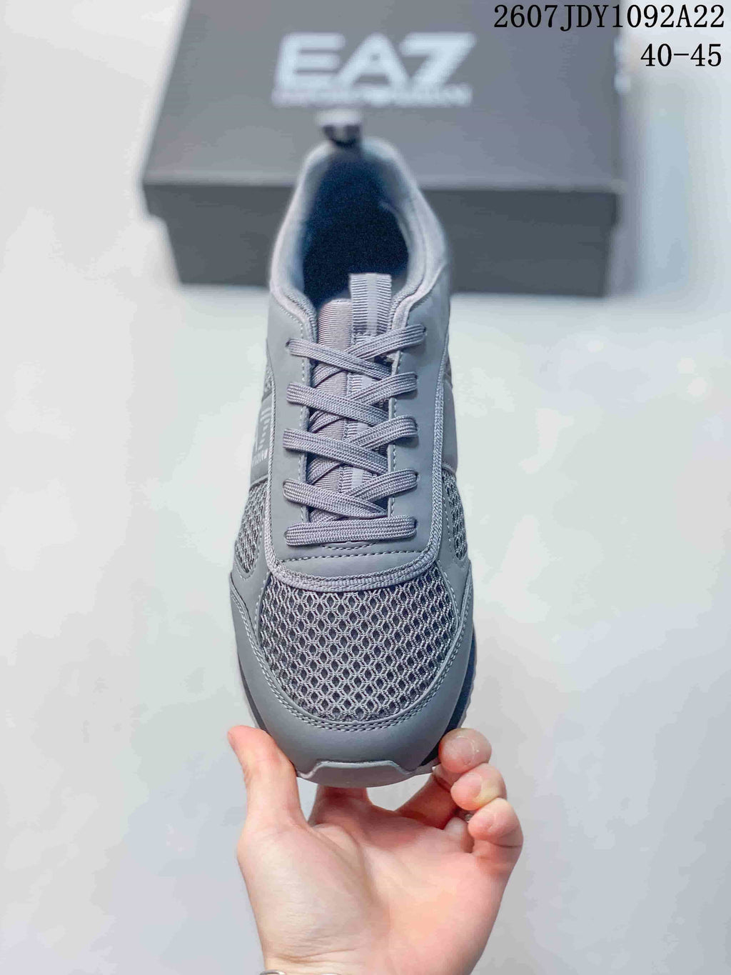 Top view of the gray sneaker showing the mesh toe panel, laces, tongue, and padded collar.