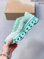 Side view of the mint green sneaker showing the gray side logo, knit-style upper, and geometric sole openings.