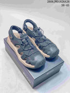 Pair of dark navy open-toe sandals with perforated panels and adjustable bungee lacing.