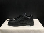 Side profile of a black low-top sneaker showing layered side panels, padded collar and light outsole inserts.
