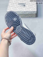 Bottom view of the sneaker showing the dark textured rubber outsole and circular tread pattern.