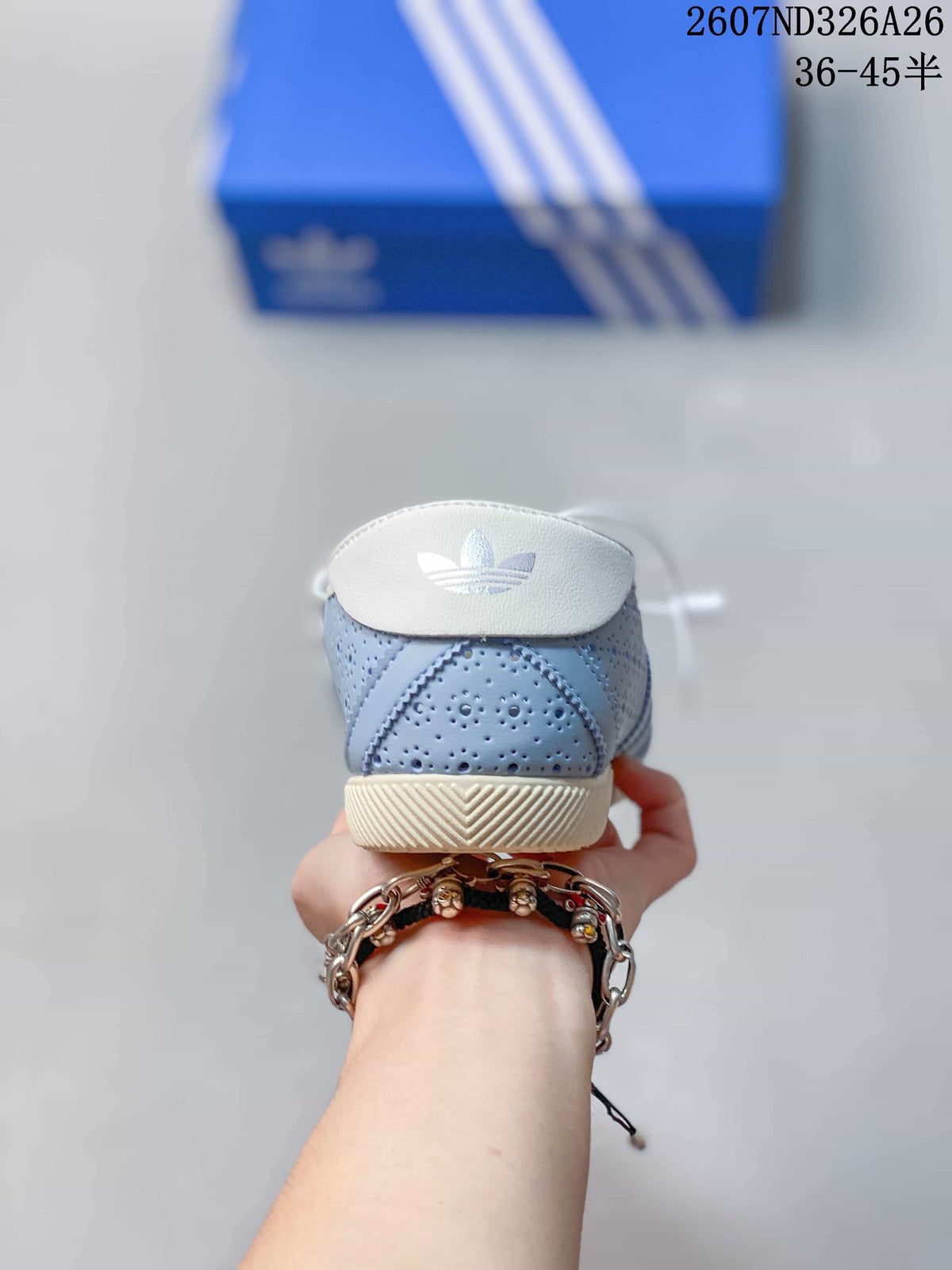 Rear view showing the light blue perforated heel, white heel tab with trefoil-style mark and cream outsole.