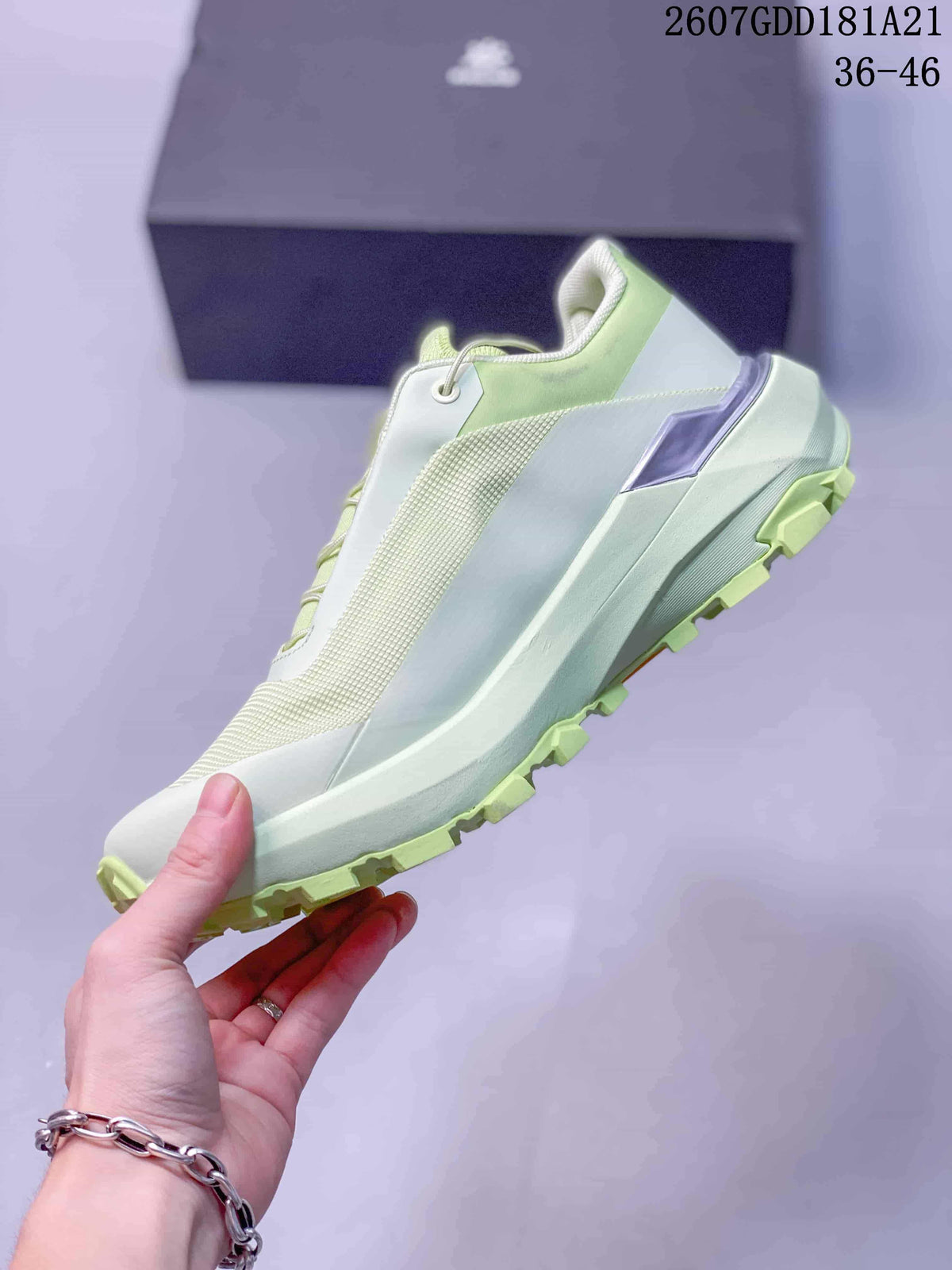 Side profile showing the pale green and white layered upper, heel detail, midsole, and lugged outsole.