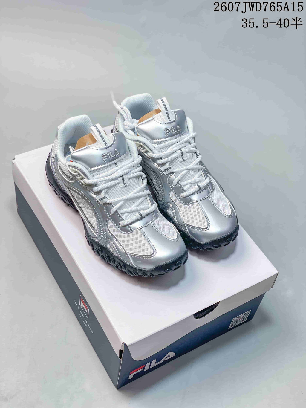 Pair of silver and white FILA Pebble low-top sneakers displayed on a FILA shoebox.