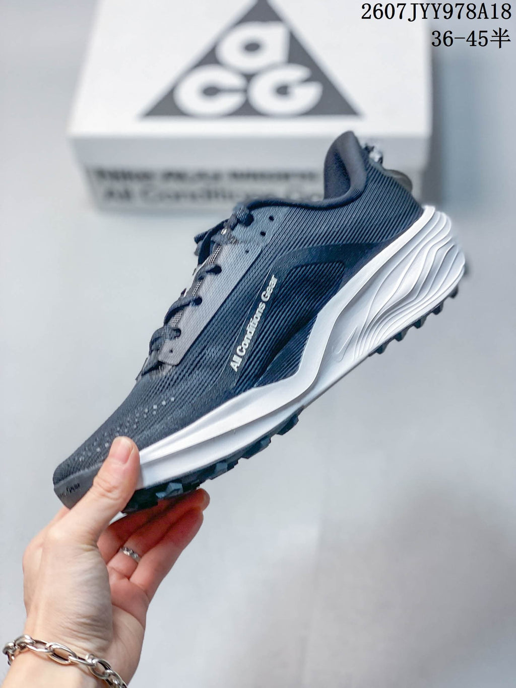 Side profile showing the dark gray textured upper, white Swoosh, ACG lettering, and layered white midsole.