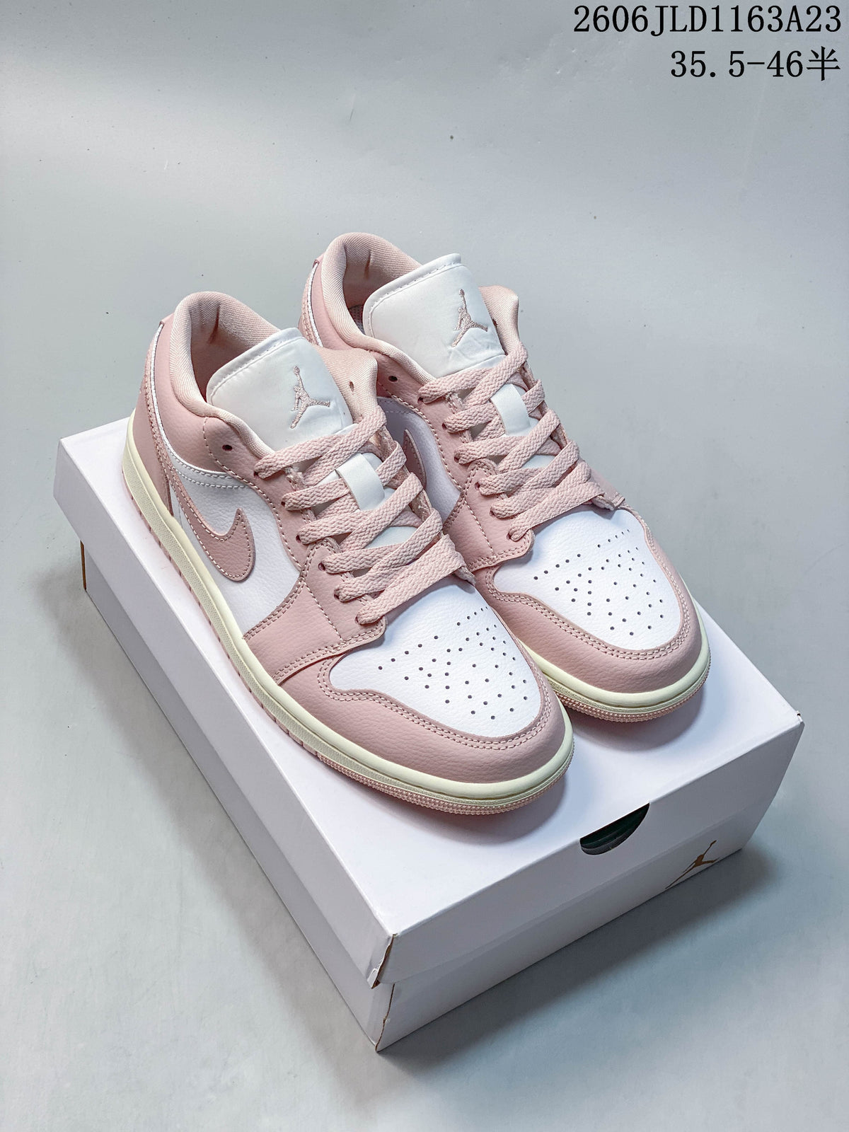 Pair of pink and white low-top Air Jordan 1 sneakers on a box