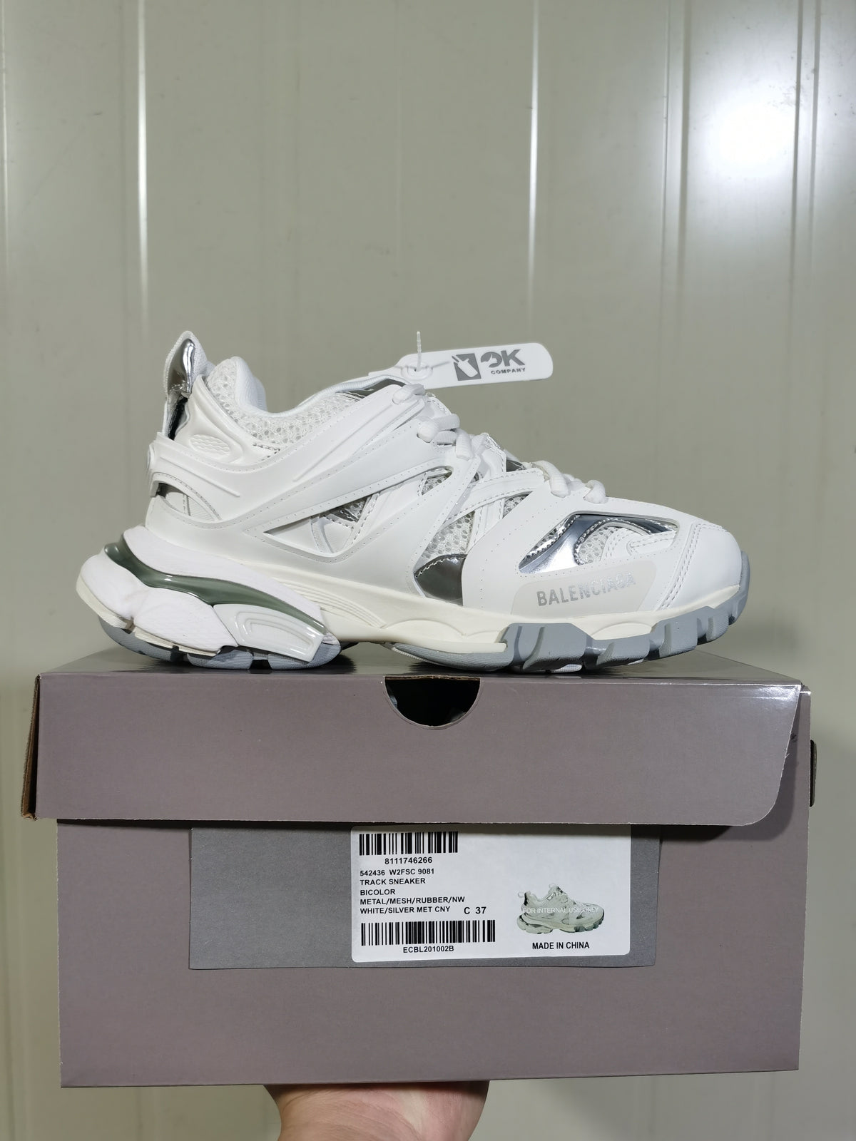 White and silver Balenciaga Track sneaker displayed on its shoe box, with the product label visible.