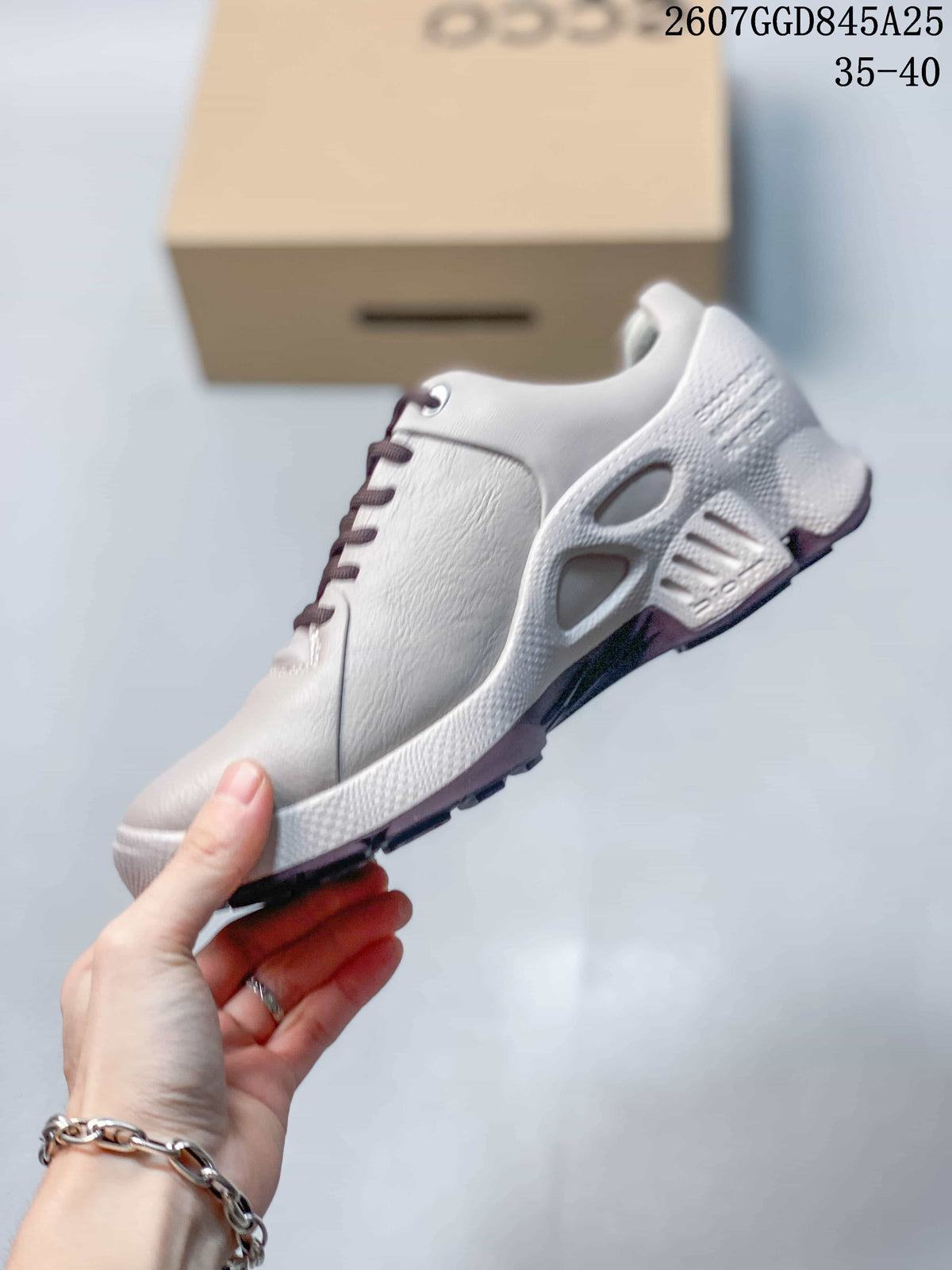 Side view of the white low-top sneaker showing the perforated upper, lace area, sculpted midsole, and outsole.