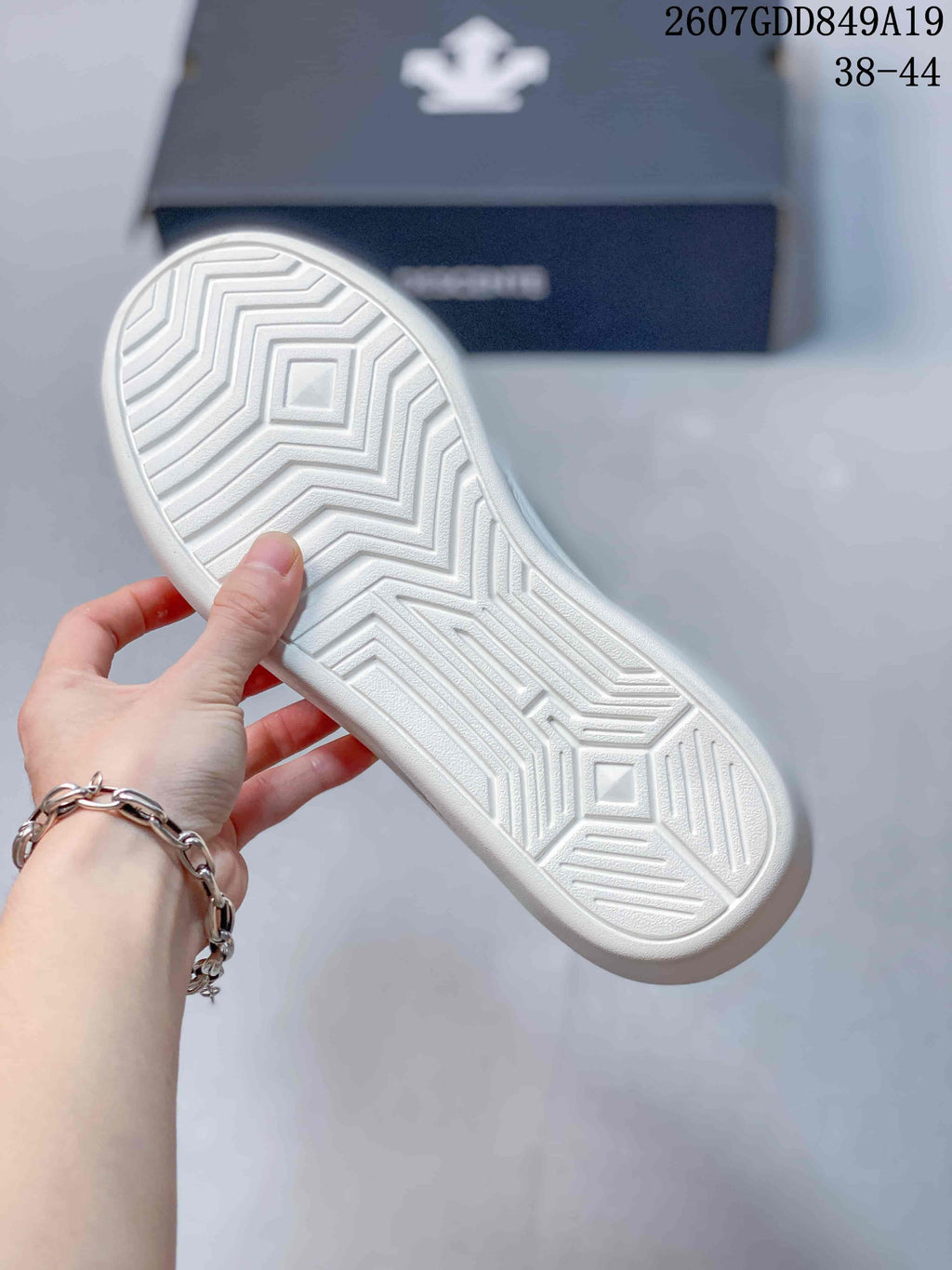 Close-up of the white rubber outsole showing a geometric zigzag traction pattern.