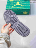 Close-up of the textured outsole of the grey Air Jordan 1 sneaker beside its box