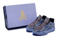 Pair of blue-gray patterned low-top basketball shoes beside a matching box