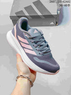Angled side view of the gray and pink lace-up running shoe.