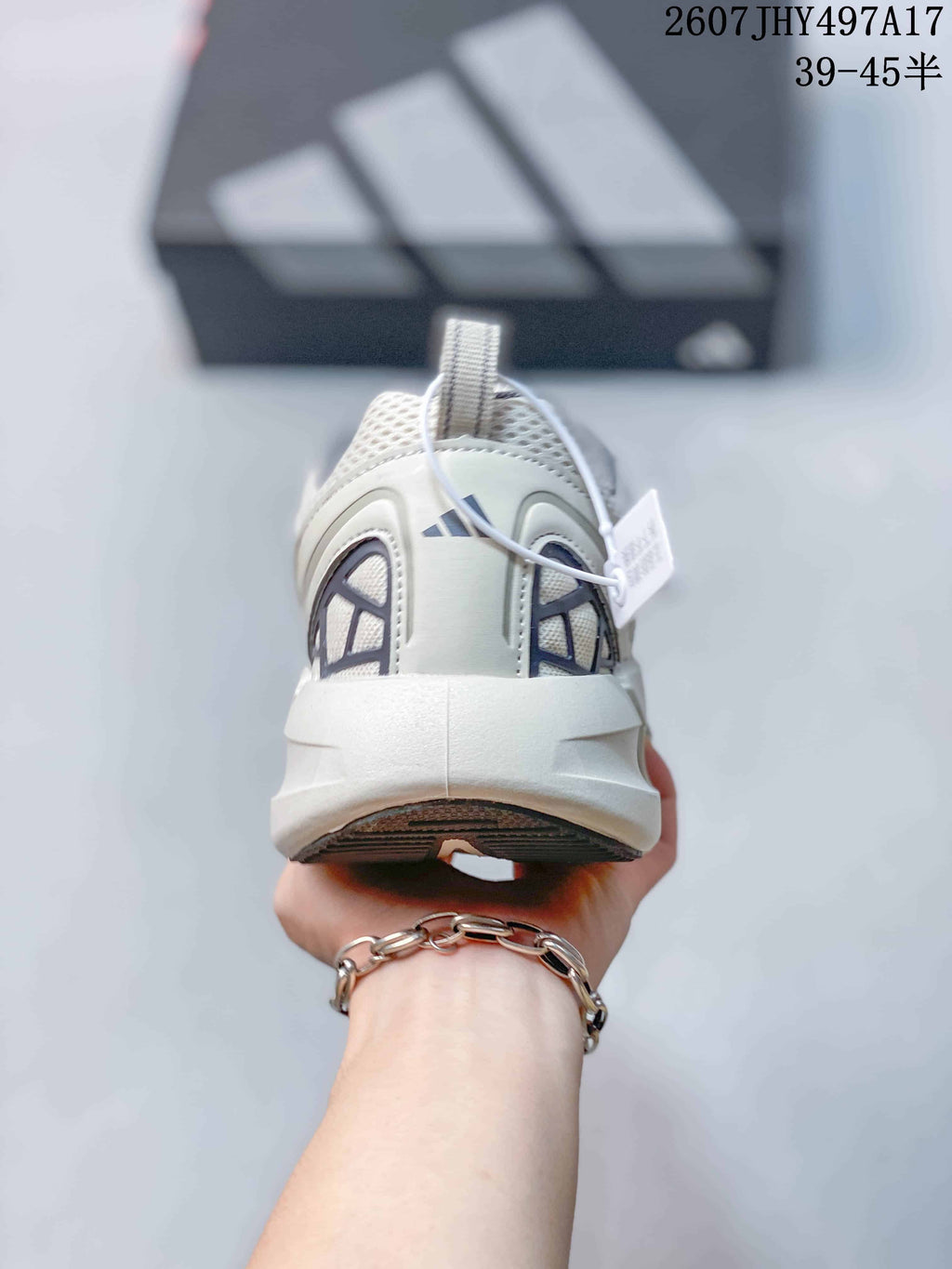 Rear view of the white and gray sneaker showing the padded collar, heel structure, and outsole.