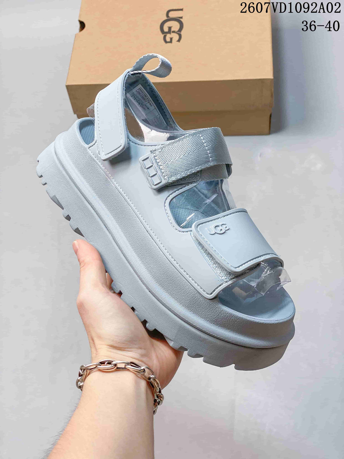 Side view of a light blue-gray platform sandal with adjustable straps and a heel strap.