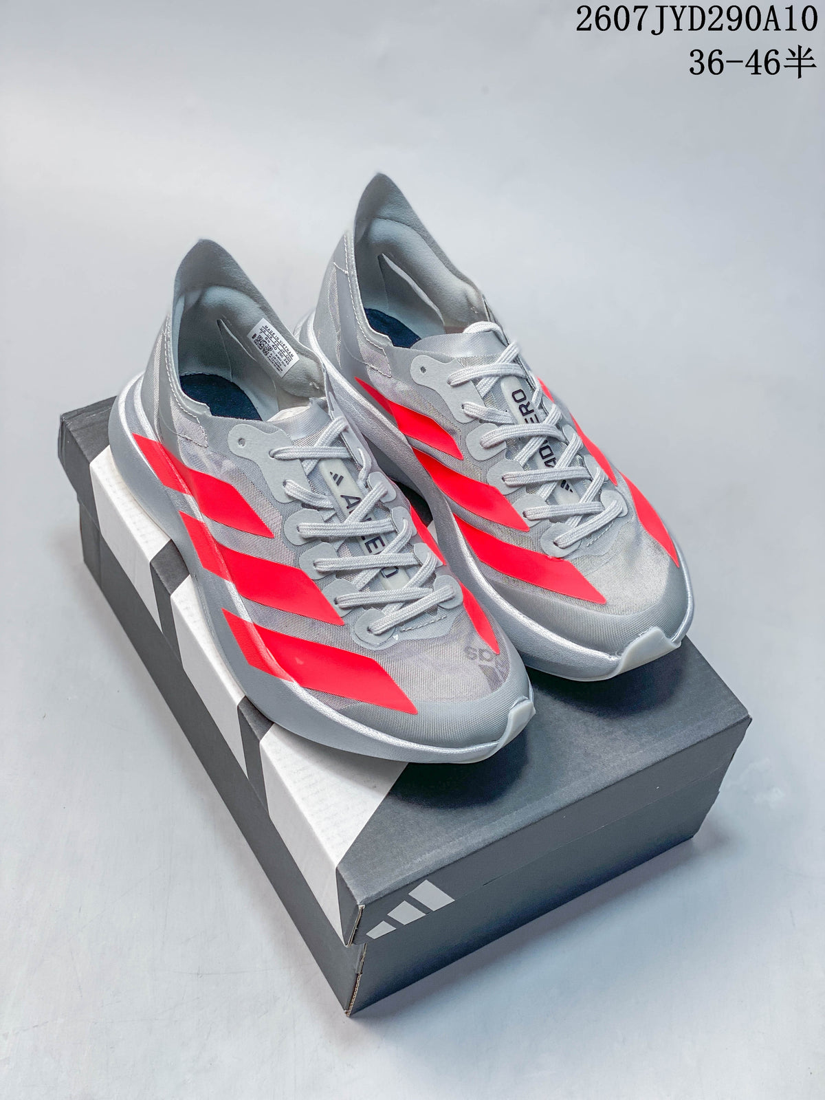 Pair of gray and red Adidas Adizero Adios Pro Evo 2 running shoes displayed on an Adidas shoebox.
