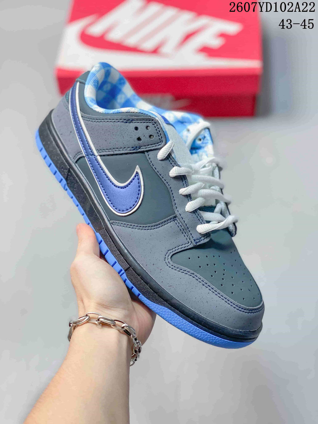 Charcoal and blue Nike SB Dunk Low Pro sneaker with white laces and a blue outsole.