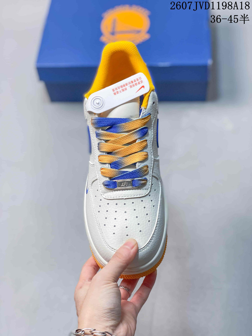 Top view showing the perforated white toe box, mixed-color laces, yellow lining, and tongue branding.