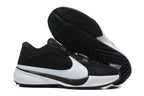 Black and white low-top basketball shoes shown with a close view of the patterned black outsole.