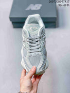 Front view of the New Balance 9060 sneaker showing the lace-up upper, mesh toe panel and tongue branding.