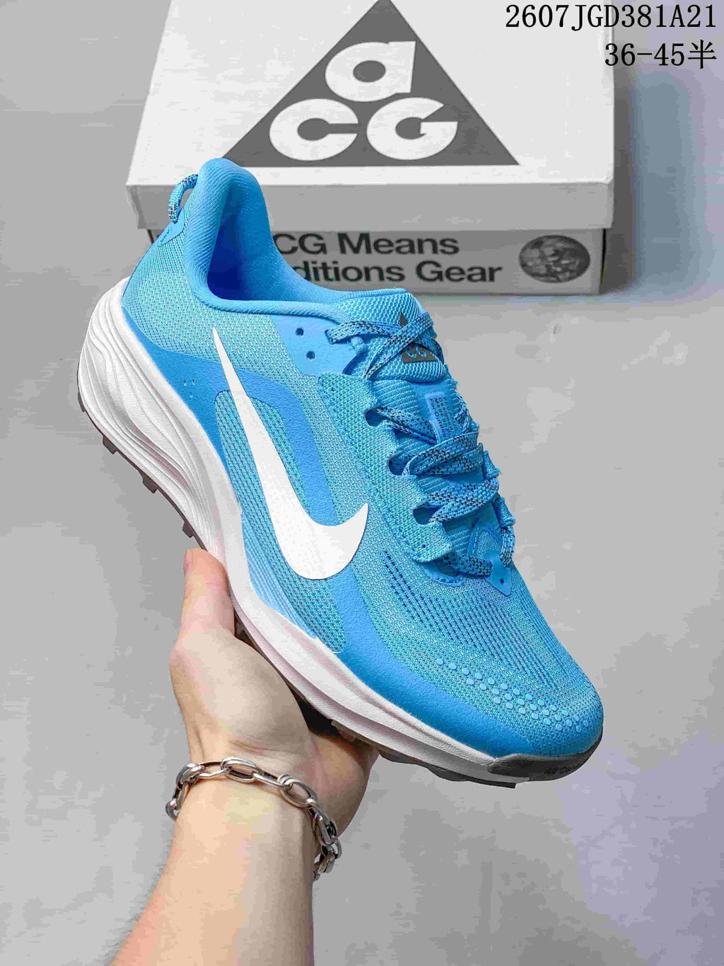 Angled side view of the blue Nike ACG Pegasus Trail sneaker with a white Swoosh, padded collar, and lugged outsole.