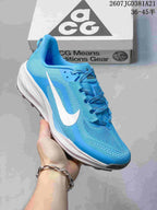 Angled side view of the blue Nike ACG Pegasus Trail sneaker with a white Swoosh, padded collar, and lugged outsole.