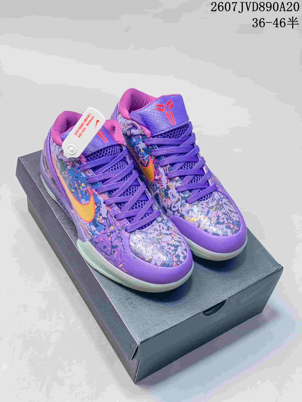 Pair of purple Nike Kobe 4 Protro basketball shoes displayed on a shoebox, showing the multicolor upper, yellow-orange Swoosh details and purple laces.