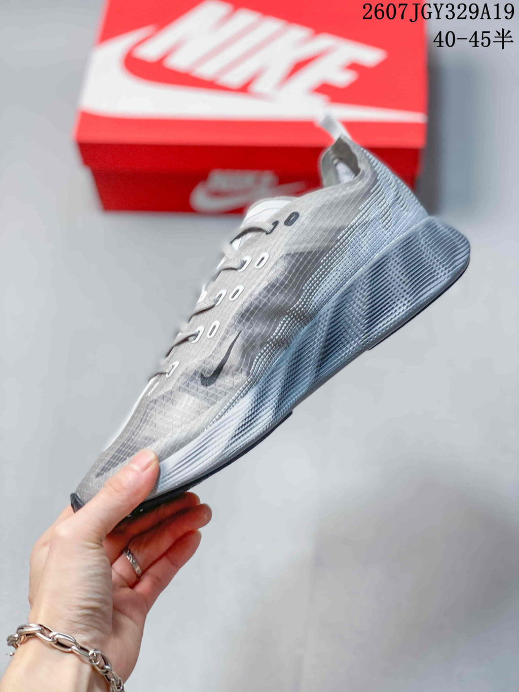 Side profile of the gray low-top sneaker showing the lace eyelets, dark side detailing, patterned upper, and layered sole.