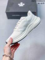 Side profile of the white sneaker showing the low-top silhouette, lace area, layered sole and textured side outsole.