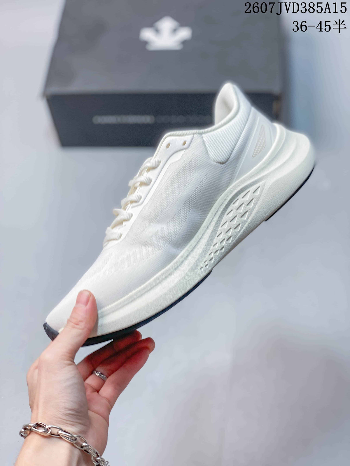 Side profile of the white sneaker showing the low-top silhouette, lace area, layered sole and textured side outsole.