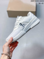 Side view of the white On shoe showing the layered upper, large On branding, raised midsole, and textured outsole.
