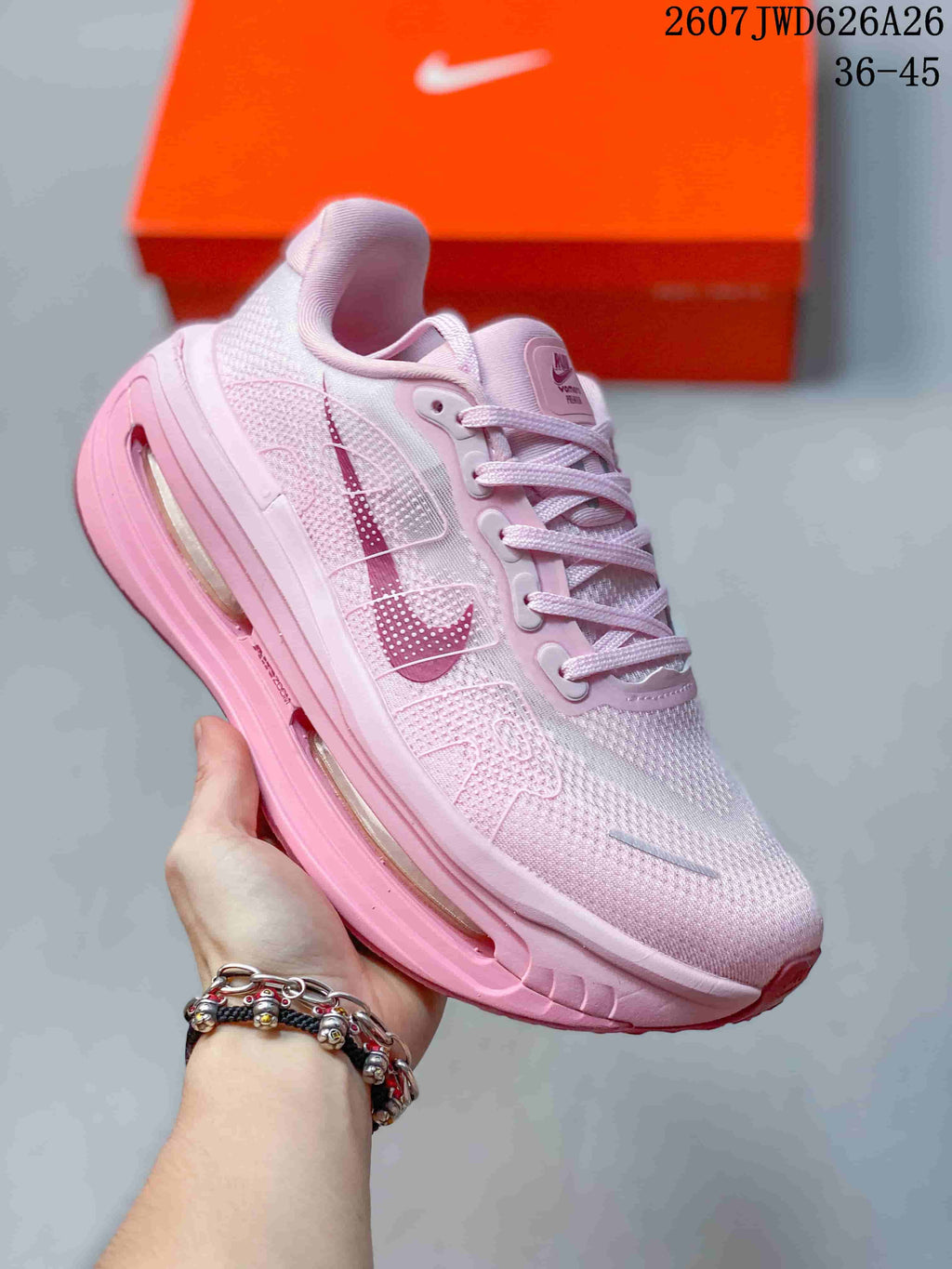 Angled side view of the pink sneaker showing the Swoosh, lace-up upper, and visible full-length cushioning unit.