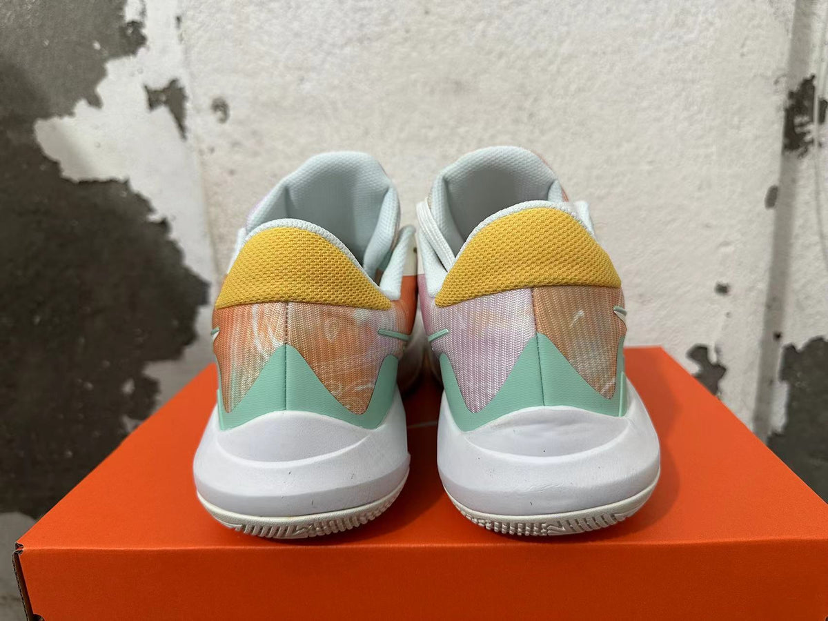 Rear view of pastel multicolor Nike basketball shoes with yellow heel panels and mint-green accents.