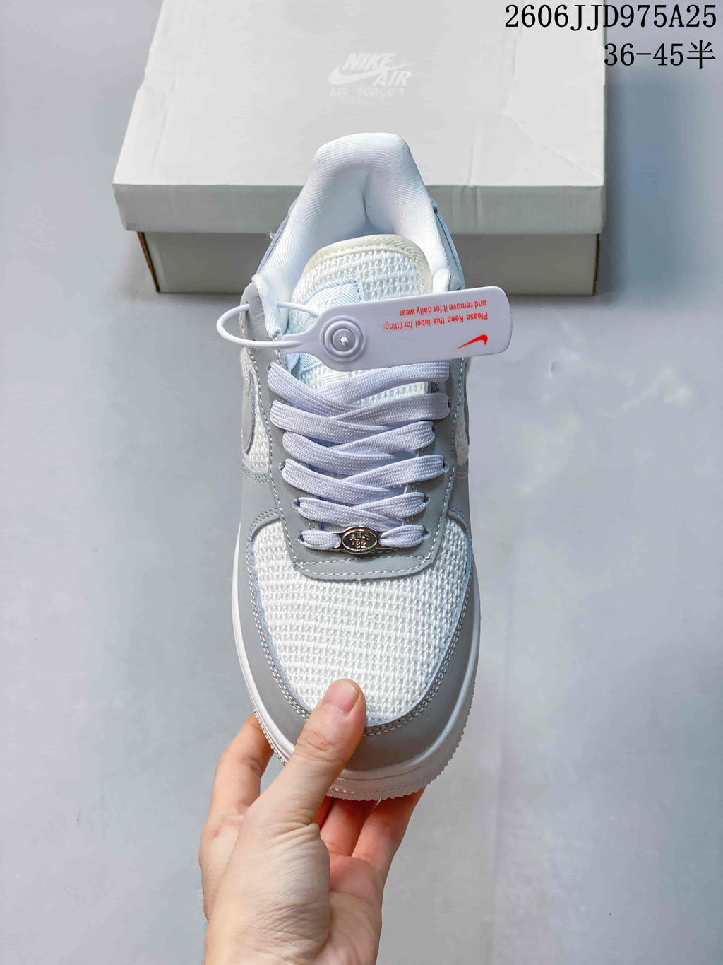 Top view of the sneaker showing the textured light upper, white laces, tongue, and decorative lace details.