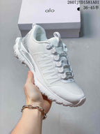 Close-up of a white Alo Trail sneaker showing its lace-up fastening and layered side panels.